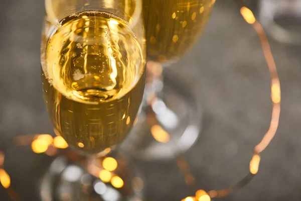 Close up of glasses of sparkling wine with blurred yellow christmas lights — Stock Photo