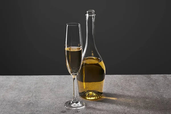 Glass and bottle of champagne for celebrating christmas on grey — Stock Photo