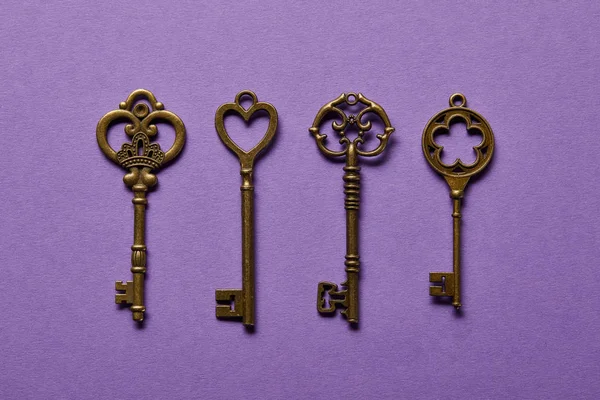 Flat lay with vintage keys on violet background — Stock Photo