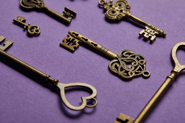 Nahaufnahme von Vintage-Schlüsseln auf violettem Hintergrund — Stockfoto