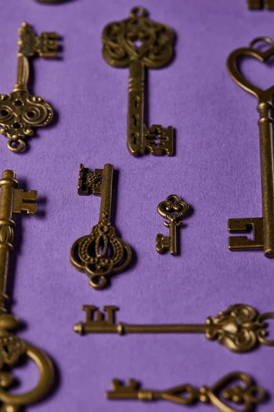 Nahaufnahme von Vintage-Schlüsseln auf violettem Hintergrund — Stockfoto