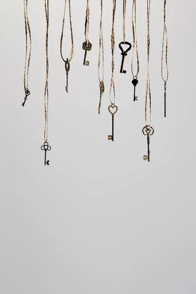 Vintage keys hanging on ropes isolated on white — Stock Photo