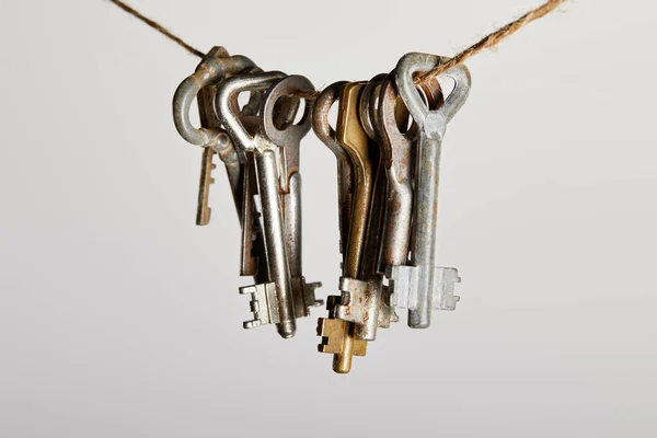 Vintage rusty keys hanging on rope isolated on white — Stock Photo