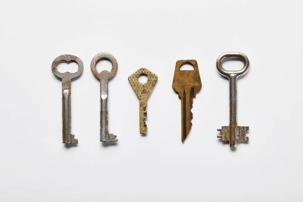 Flat lay with vintage rusty keys on white background — Stock Photo