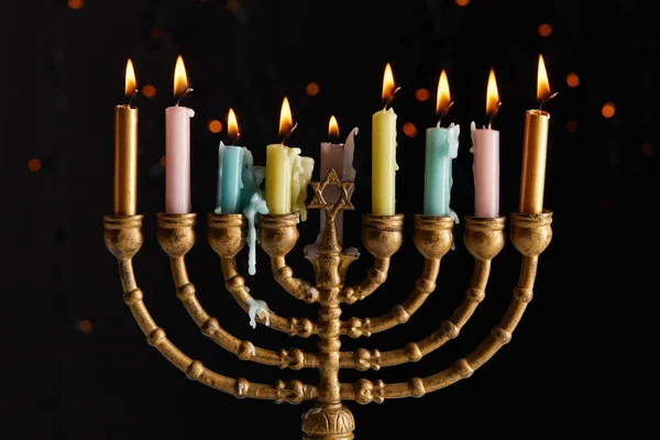 Bougies incandescentes dans la menorah sur fond noir avec des lumières bokeh sur Hanoukka — Photo de stock