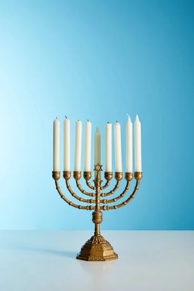 Candles in menorah on blue background — Stock Photo