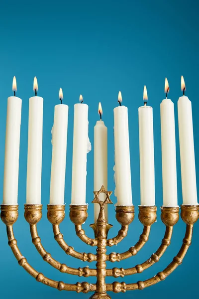 Brûlant des bougies dans menorah isolé sur bleu — Photo de stock