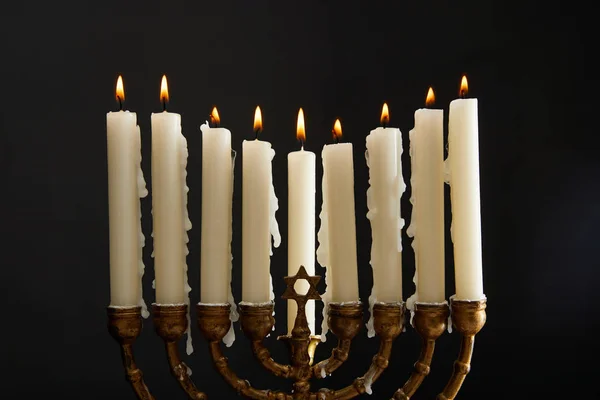 Velas encendidas en menorah en Hanukkah aislado en negro - foto de stock