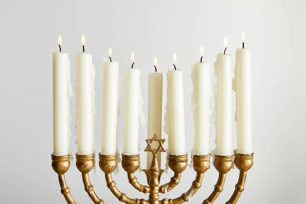 Velas encendidas en la menorá en Hanukkah aislado en blanco - foto de stock