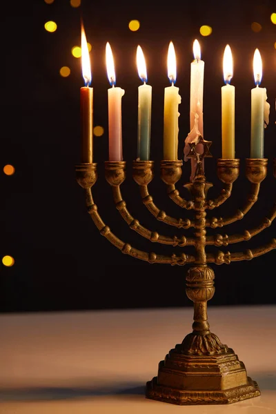 Burning candles in menorah on black background with bokeh lights on Hanukkah — Stock Photo