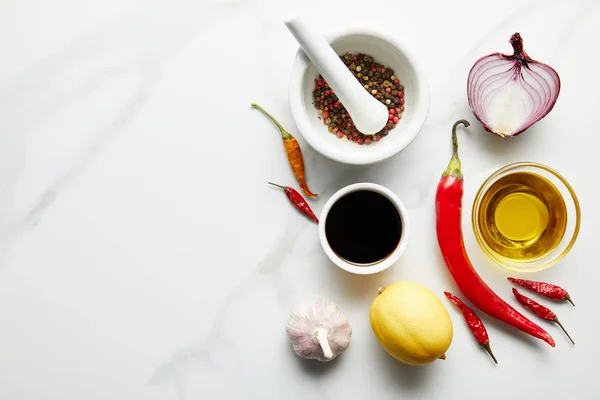 Vista superior de la salsa de soja con aceite de oliva y especias sobre fondo de mármol - foto de stock