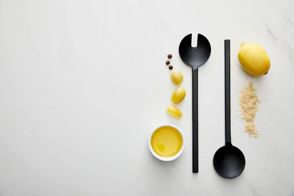 Top view of olive oil with lemon, cherry tomatoes and ladle with spoon on marble background — Stock Photo