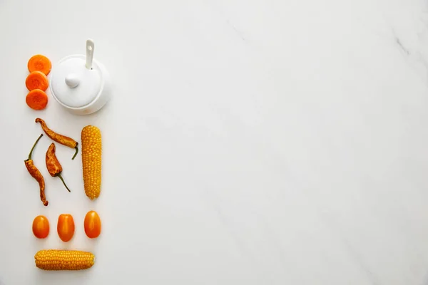 Верхний вид соусника с овощами и перцем чили на мраморном фоне — стоковое фото