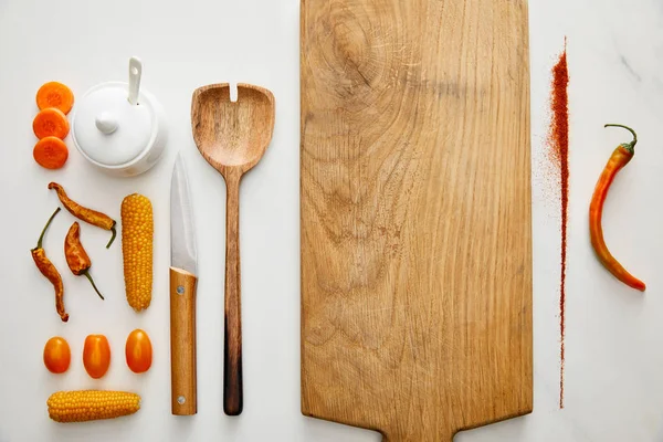 Top view of kitchenware with vegetables and chili pepper spice on marble background — Stock Photo