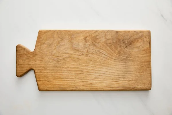 Top view of wooden cutting board on marble background — Stock Photo