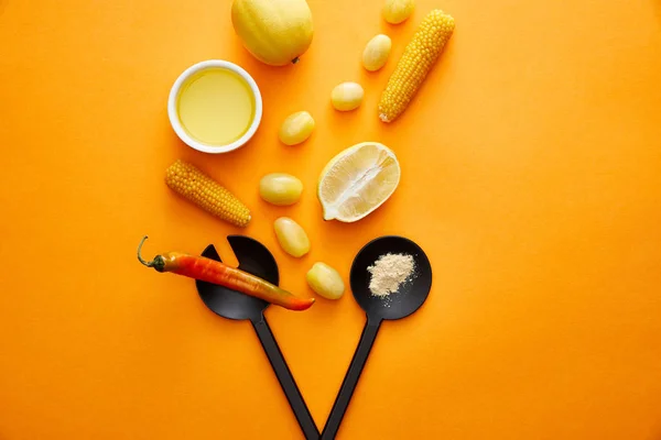 Vista dall'alto di utensili da cucina con verdure e olio d'oliva su sfondo arancione — Foto stock