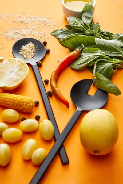 Hortalizas ecológicas con limones y albahaca sobre fondo naranja - foto de stock