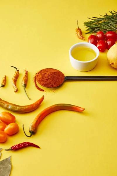 Pimenta com legumes e azeite sobre fundo amarelo — Fotografia de Stock