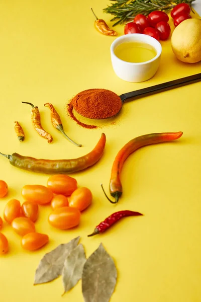 Перець чилі зі спеціями та стиглими овочами на жовтому фоні — стокове фото
