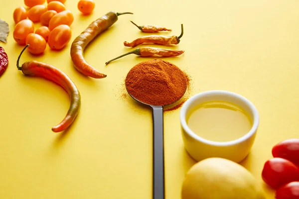 Chili peppers with spice and olive oil on yellow background — Stock Photo