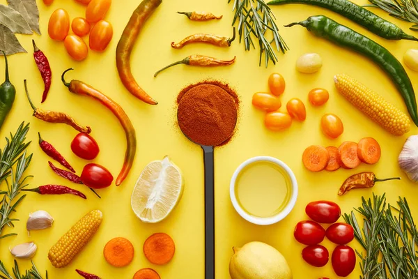 Vue du dessus des légumes et herbes biologiques avec du piment sur fond jaune — Photo de stock