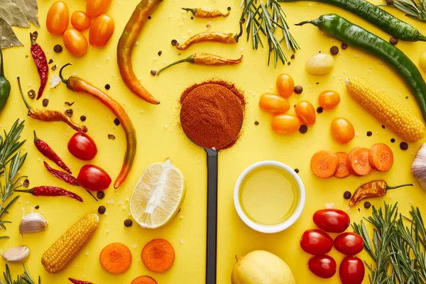 Вид сверху на экологически чистые овощи со специями и оливковым маслом в миске на желтом фоне — стоковое фото