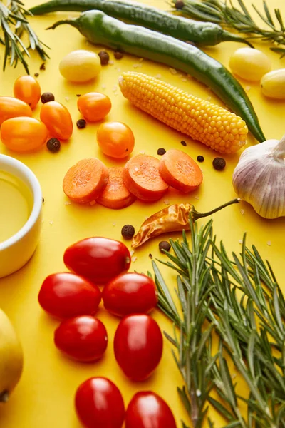 Romarin frais avec légumes, épices et huile d'olive sur fond jaune — Photo de stock