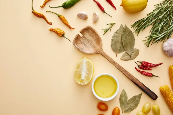 Top view of wooden spoon with spices and vegetables on beige background — Stock Photo