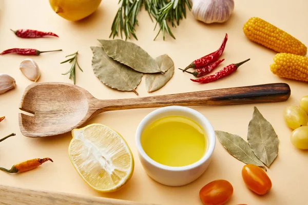 Оливковое масло с органическими овощами и розмарином на бежевом фоне — стоковое фото