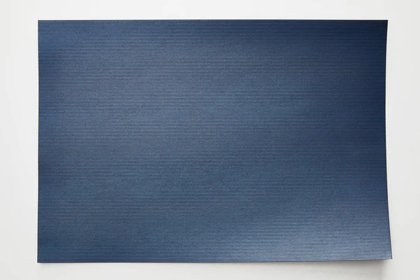 Vue du dessus du papier bleu vide rayé sur fond blanc — Photo de stock