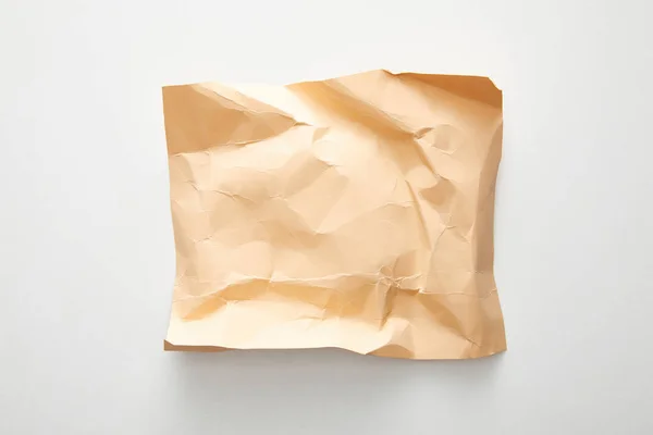 Top view of empty crumpled and burnt beige vintage paper on white background — Stock Photo