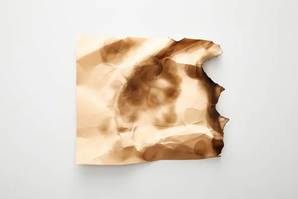 Вид зверху порожній зім'ятий і спалений бежевий вінтажний папір на білому тлі — стокове фото