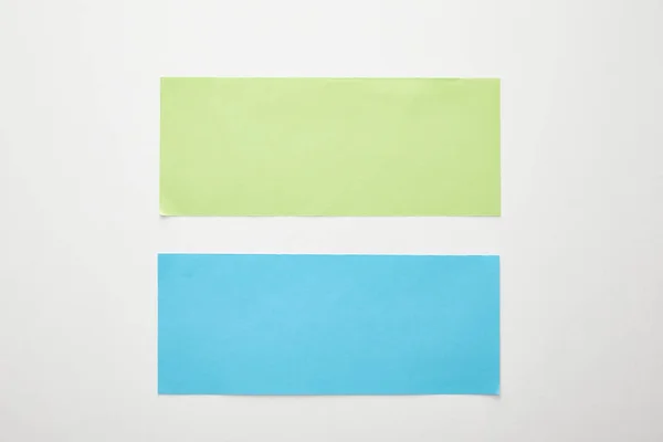 Вид сверху пустой голубой и зеленой бумаги на белом фоне — стоковое фото