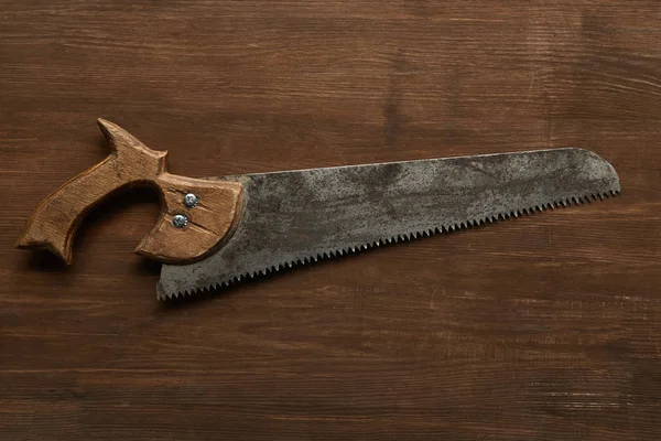 Top view of old rusty saw on wooden table — Stock Photo