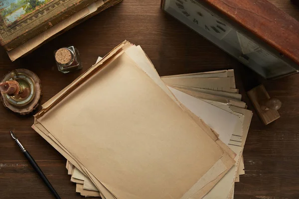 Vue du dessus du papier vintage, peinture, stylo plume, timbre et horloge sur table en bois — Photo de stock