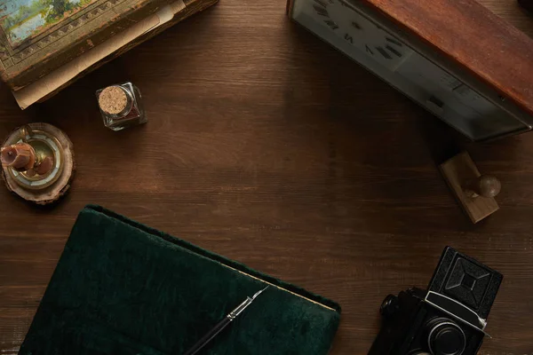 Vue du dessus de l'appareil photo vintage, album photo, peinture, stylo plume, timbre et horloge sur la table en bois — Photo de stock