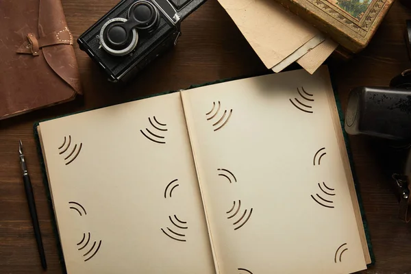 Top view of vintage camera, photo album, painting, fountain pen, seal on wooden table — Stock Photo