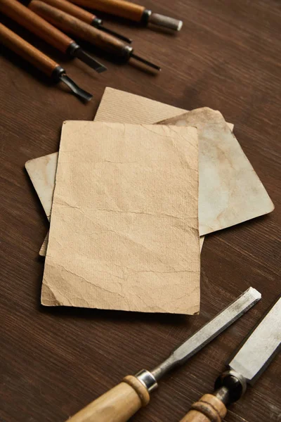 Ferramentas de carpintaria perto de papéis vintage em branco na mesa de madeira — Fotografia de Stock