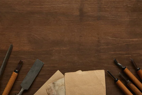 Vue du dessus des vieux outils de menuiserie près de papiers vintage vierges sur table en bois — Photo de stock