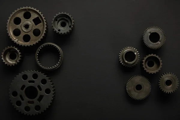 Top view of aged gears on black surface — Stock Photo