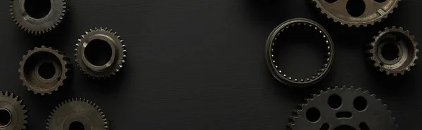 Top view of aged gears on black surface, panoramic shot — Stock Photo