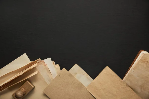 Vue du dessus du papier vintage et timbre sur fond noir — Photo de stock