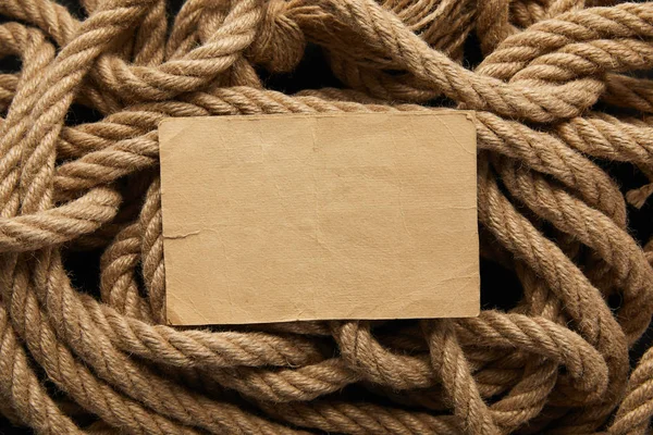 Vue du dessus du papier blanc vintage et de la corde sur fond noir — Photo de stock