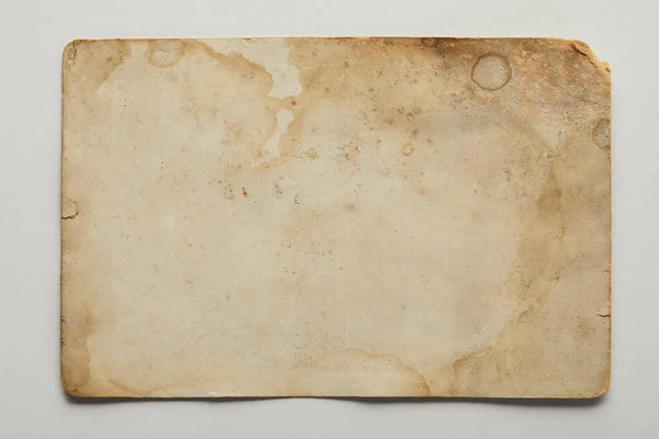 Вид зверху на старовинний брудний бежевий папір на сірому фоні — стокове фото