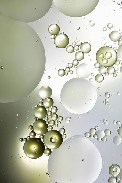 Fondo abstracto de burbujas mixtas de agua y aceite en color verde claro y gris - foto de stock