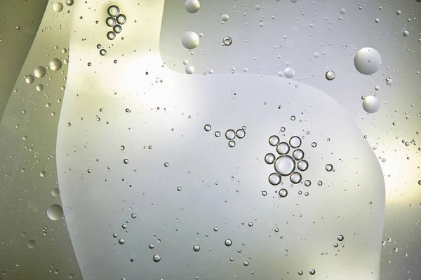 Beautiful background from mixed water and oil bubbles in light green and grey color — Stock Photo