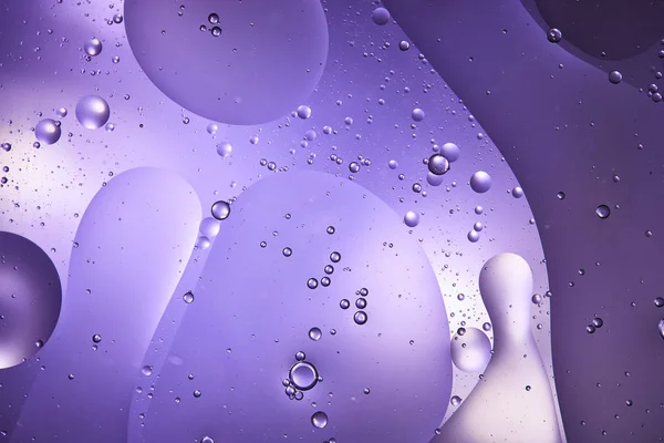 Абстрактна фіолетова кольорова текстура зі змішаної води та олійних бульбашок — стокове фото