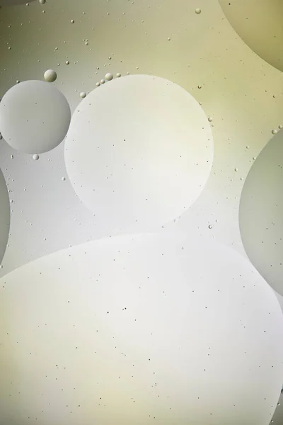 Світло-зелений і сірий кольоровий фон зі змішаної води і масляних бульбашок — стокове фото