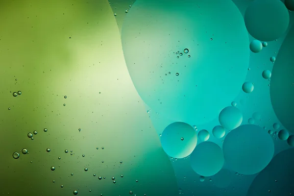 Abstract background from mixed water and oil bubbles in green and turquoise color — Stock Photo