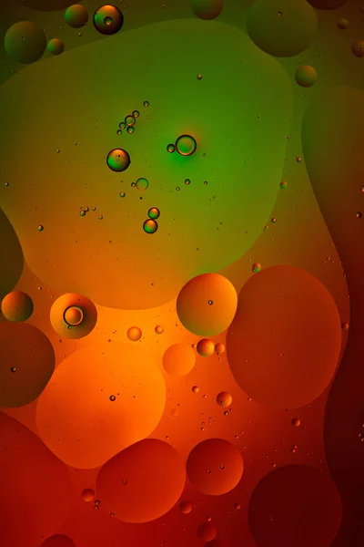 Fondo abstracto de agua mezclada y burbujas de aceite en color verde y rojo - foto de stock